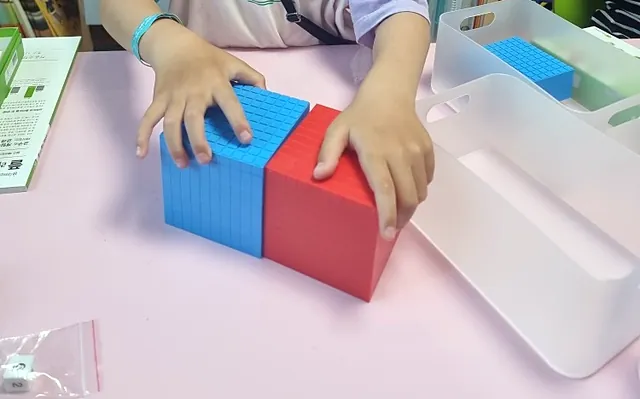수 모형 큐브를 쌓아 자릿값을 알아보는 손